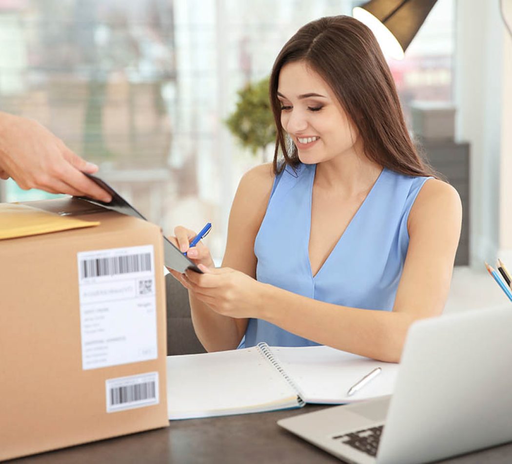 Woman signing documents after receiving parcel from courier